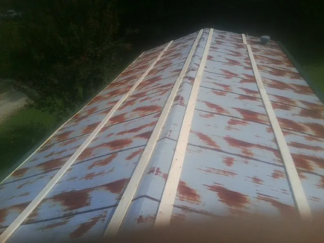 Rusted metal roof panels with new wood purlins before replacement — Storm Damage Roof Repair in Siler City by Roofing Brothers