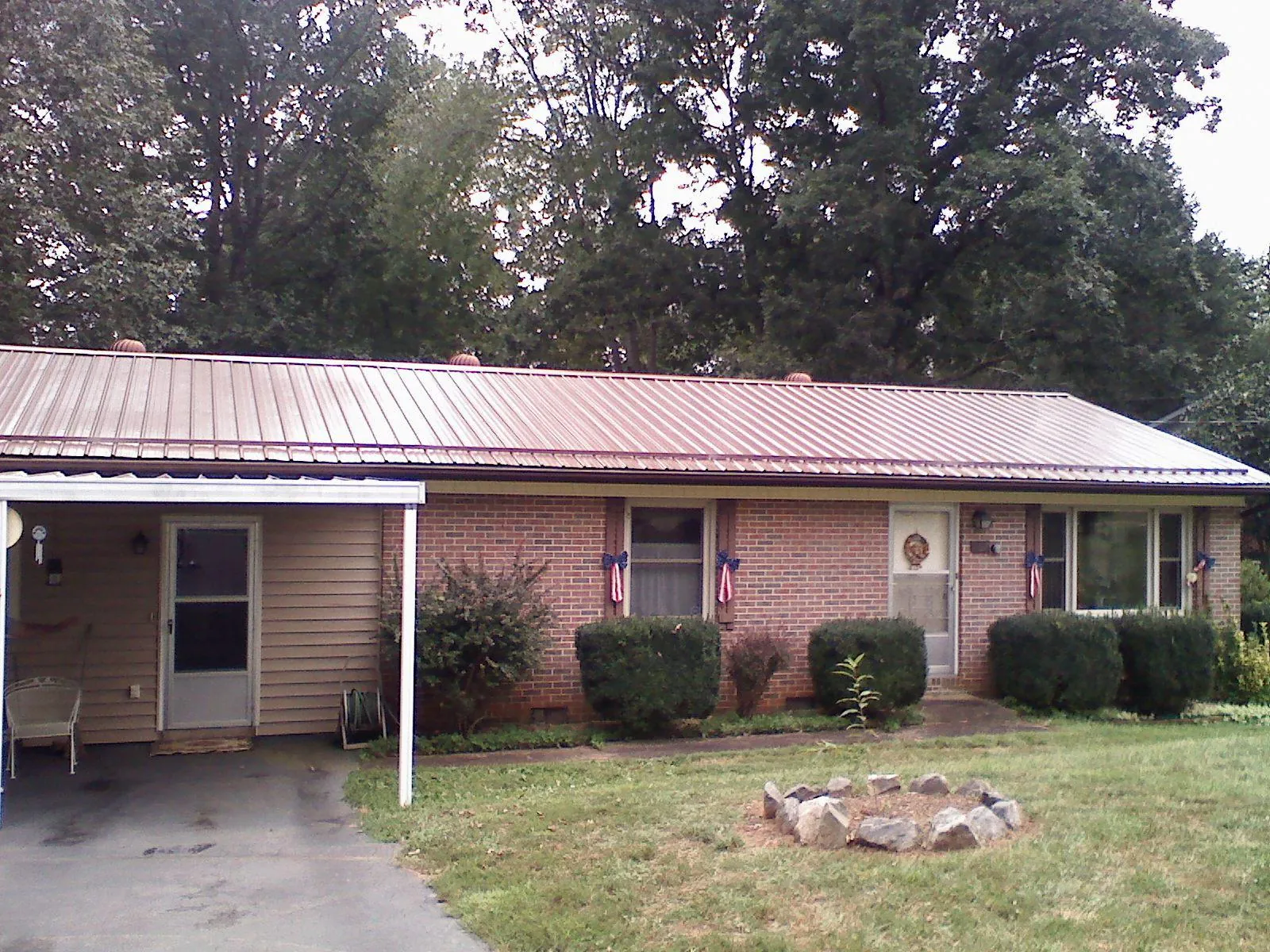 Bronze metal roof and carport on a brick ranch home — Roof Repair work by our crew in Siler City