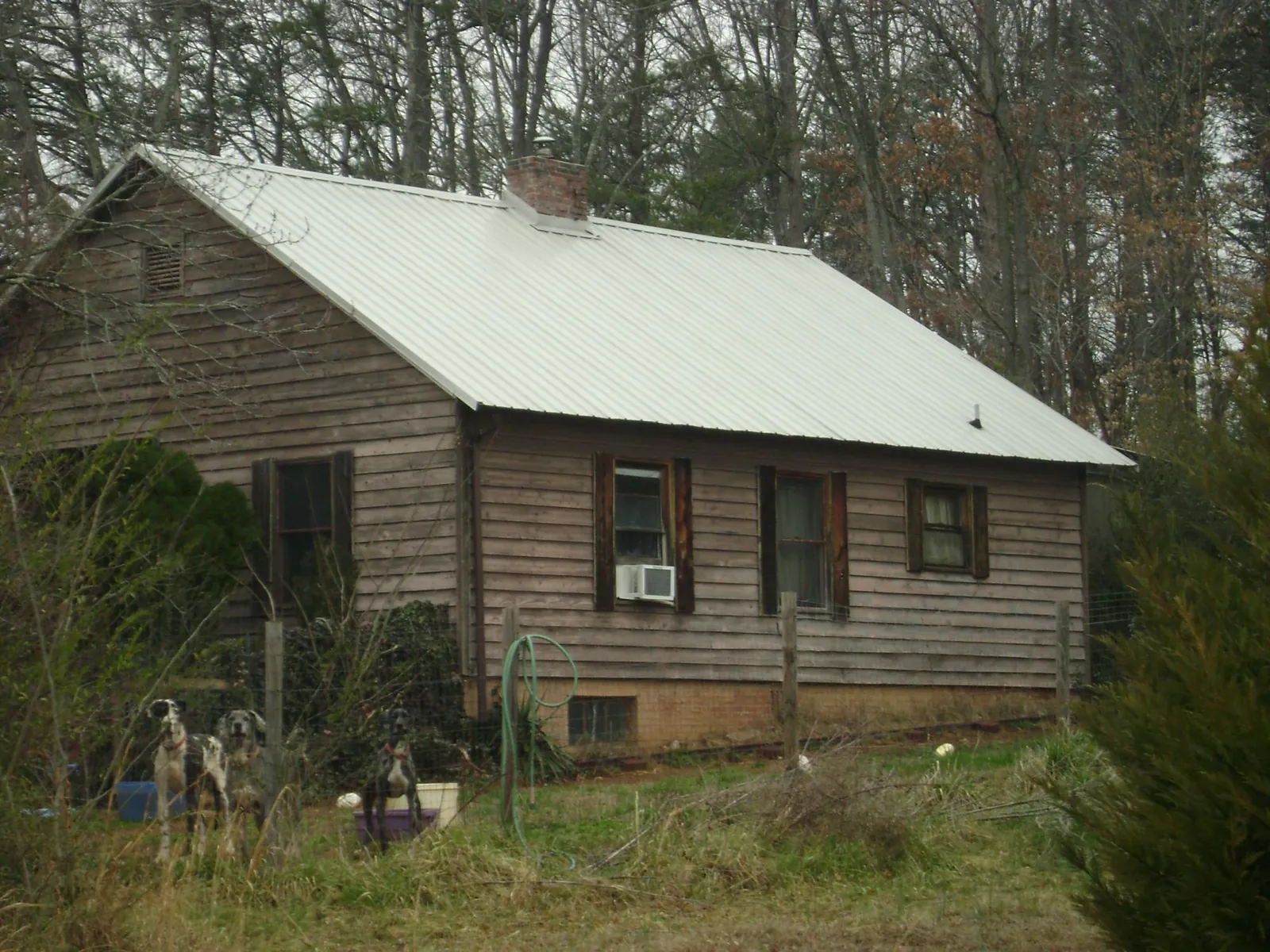White metal roof on an old wood sided farmhouse, from a Metal Roof Installation job in Siler City